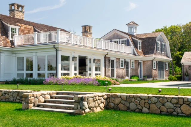 Classic Shingle Style details define this Falmouth retreat, from gambrel roofs and weathered cedar shingles to stone chimneys and a cupola-topped pavilion. Terraces, formal gardens, and inviting outdoor living spaces culminate in a summer-ready pool area designed for timeless coastal enjoyment.

Architect: @patrickahearnarchitect 
Photo Credit: @taylor.allegrini