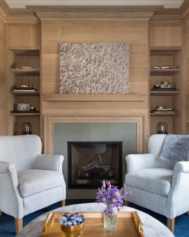 Gather 'round! Limewashed v-groove paneling graces the walls of this fireplaced den, which calls friends to stop in and stay awhile beside the warm hearth.

Architect: @patrickahearnarchitect
Builder: Burnham + Magnuson Builders
Interior Design: @karenbowinteriors
Photo Credit: @AmyVischio
