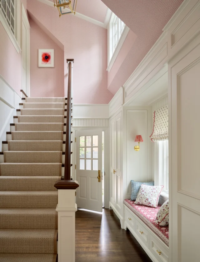 The casual family entrance within this renovated Brookline, Massachusetts, residence offers easy access from the exterior. A staircase leads to comfortable guest quarters that provide a getaway space for visiting family and friends.

Architecture: @patrickahearnarchitect
Builder: @falloncustomhomes
Interior Design: @annsleyinteriors
Art Advising: @thewellfineart
Photo Credit: @seanlitchfield
Stylist: @francesfinds