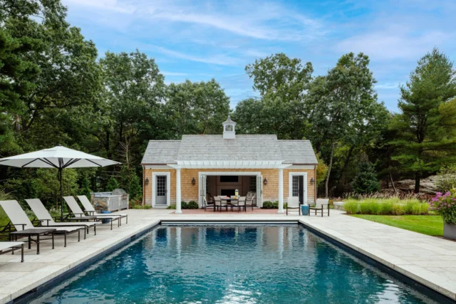 A timeless poolside cabana in Hingham, MA, clad in cedar shingles and crowned with a graceful cupola, its central doors opening wide to invite in the breeze and anchor summer days with quiet coastal ease.

Architecture: @patrickahearnarchitect
Builder: @colcloughconstruction
Photo Credit: @gregpremru