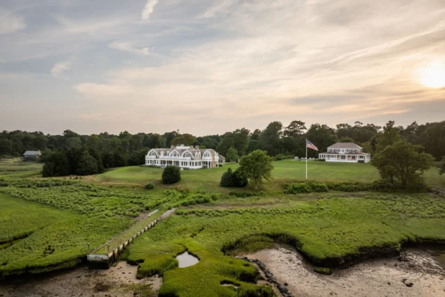 Set along Duxbury Bay, this legacy property pairs a main house and guest house within a romantic waterfront landscape of sweeping lawns and expansive water views. Covered rear porches, defined by classical columns and timeless materials, create a seamless indoor-outdoor experience for both structures.

Architecture: @patrickahearnarchitect
Builder: @jbrobbiecustomhomes
Landscape: @leblancjones
Photo Credit: @crucinski_