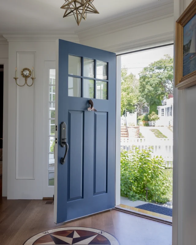 The formal entry door swings wide at this newly built Edgartown Harbor home, inviting guests inside. Architectural wall paneling continues into the stairway, which features a star-studded light installation.

Architecture: @patrickahearnarchitect
Builder: @colonial_reproductions
Interior Design: @lesliefineinteriors
Photo Credit: @michaeljleephotography
Styling: @juliaheffhome