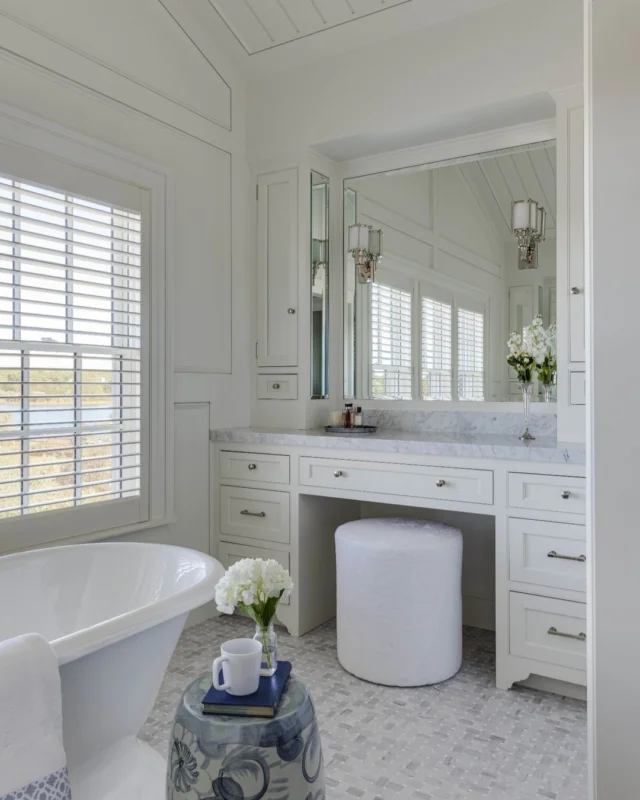 With views of Slough Cove from the soaking tub, the sumptuous primary bathroom of this newly built Edgartown residence features the same elevated level of interior architectural detail as the rest of the home, including custom milled wall paneling, custom built cabinetry, and beadboard to please.

Architecture: @patrickahearnarchitect
Builder: @colonial_reproductions
Interior Design: @trackerhomedecor
Photo Credit: @gregpremru
Styling: @cmack2002