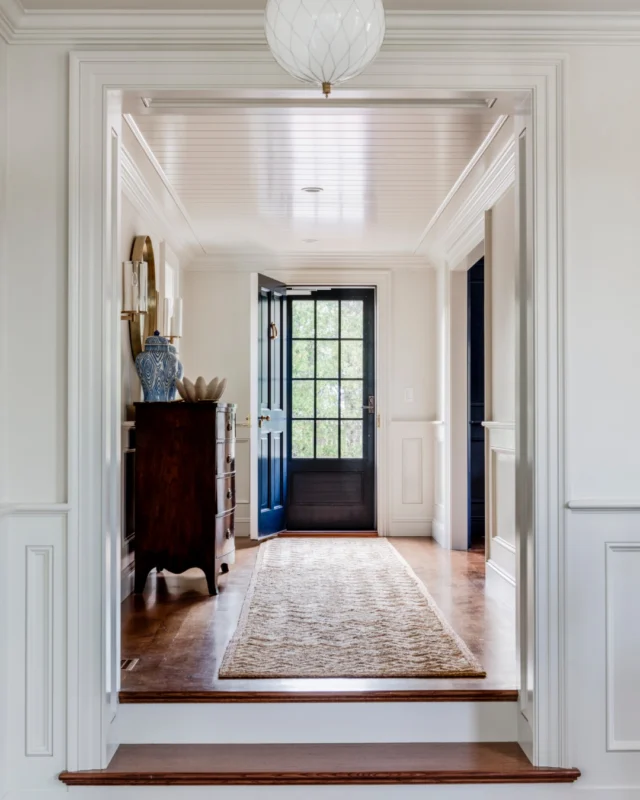 Within this Greek Revival residence, a gracious foyer gives way to a classically detailed staircase, where crafted balusters and a sweeping handrail reflect the home's architectural character. A paneled ceiling, custom millwork, and a divided-light storm door bring depth and refinement to the entry.

Architecture: @patrickahearnarchitect
Builder: @whitlabrothersbuilders
Interior Designer: @digsdesignco
Landscape: Copper Moon Landscaping
Photo Credit: @gregpremru